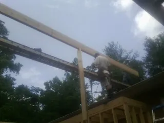 Carpenter setting a ridge beam over a new addition frame — Ice Dam Removal by Roofing Brothers in Broadway