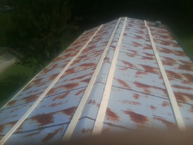 Rusted metal roof panels with new wood purlins before replacement — Storm Damage Roof Repair in Broadway by Roofing Brothers